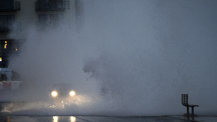 Une voiture au milieu des vagues, sur une promenade de bord de mer &agrave;&nbsp;Scarborough dans le nord de l'Angleterre, le 5 d&eacute;cembre 2013. (NIGEL RODDIS / REUTERS)