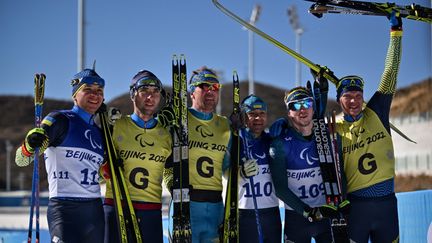 Malgré la guerre dans leur pays, les athlètes ukrainiens parviennent à esquisser un sourire. Vitaliy Lukyanenko, Oleksandr Kazik et Dmytro Suiarko, engagés sur le 6 km sprint en biathlon, ont signé un triplé dans la catégorie déficient visuel, le&nbsp;5 mars 2022. Ce podium, symbolique à plus d'un titre, restera l'un des temps forts de la première journée&nbsp;des Jeux paralympiques&nbsp;de Pékin. (LILLIAN SUWANRUMPHA / AFP)