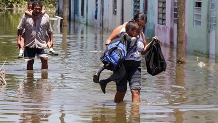 Des habitants de Villahermosa, dans l'Etat mexicain de Tabasco, marchent dans une rue inondée (07/09/10) (AFP / Gilberto Villasana)