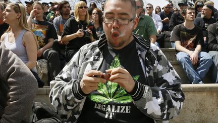 Un homme fume du cannabis lors d'un rassemblement &agrave; Denver, dans le Colorado (Etats-Unis), le 20 avril 2013. (RICK WILKING / REUTERS)