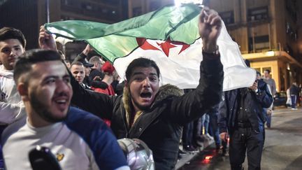 Des Algériens font la fête après le renoncement&nbsp;d'Abdelaziz Bouteflika à un cinquième mandat,&nbsp;le 11 mars 2019, à Alger. (RYAD KRAMDI / AFP)