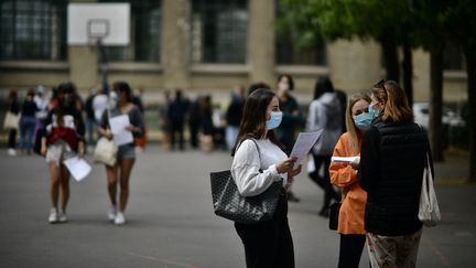 Des élèves consultent les résultats du baccalauréat, le 7 juillet 2020 à Paris. (MARTIN BUREAU / AFP)