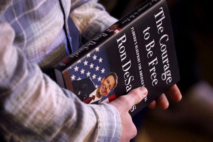 Un participant tient les mémoires de Ron DeSantis lors d'un événement promotionnel à Des Moines, dans l'Iowa (Etats-Unis), le 10 mars 2023. (SCOTT OLSON / GETTY IMAGES NORTH AMERICA / AFP)