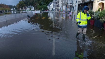 Un homme dans une rue inondée de Quimperlé, dans le Finistère, le 28 octobre 2023. (FRED TANNEAU / AFP)