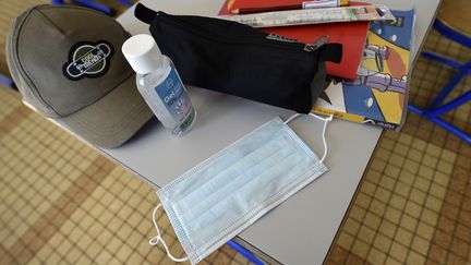 Un masque et du gel hydroalcoolique sur la table d'un écolier à Villers-lès-Nancy (Meurthe-et-Moselle), le 12 mai 2020. (JEAN-CHRISTOPHE VERHAEGEN / AFP)