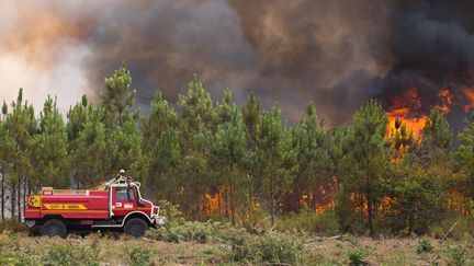 Un camion de pompier tente de maîtriser un brasier dans le secteur de&nbsp;Saint Magne, en Gironde, l'après-midi du 11 août. (LAURENT PERPIGNA IBAN / HANS LUCAS)