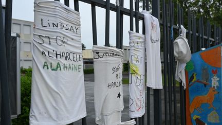 Des t-shirts accrochés à la grille du collège où était scolarisée Lindsay, le 18 juin 2023, à Vendin-le-Vieil (Pas-de-Calais). (DENIS CHARLET / AFP)