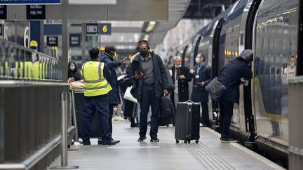 Des passagers montent à bord d'un train Eurostar à la gare de Saint Pancras à Londres, le 23 décembre 2020. Photo d'illustration. (TOLGA AKMEN / AFP)