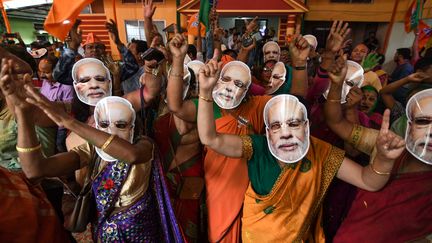 Des partisans du Premier ministre indien Narendra Modi portant des masques à son effigie dans l'attente des résultats des élections législatives, le 23 mai 2019, à Guwahati (Inde). (BIJU BORO / AFP)