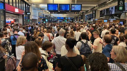 Des passagers attendent dans le hall de la gare Montparnasse, à Paris, après la panne survenue vendredi 28 juillet. (WILLY MOREAU / RADIO FRANCE)