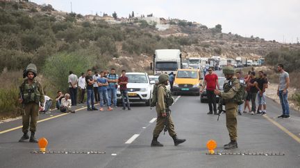 Des soldats israéliens bloquent une route,&nbsp;le 7 octobre 2018, après une attaque meurtrière dans&nbsp;la zone industrielle de Barkan en Cisjordanie.&nbsp; (ISSAM RIMAWI / ANADOLU AGENCY / AFP)