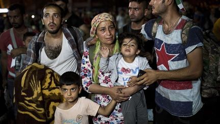 Des centaines de migrants sont rassemblés en attendant de monter à bord d'un ferry qui les mènera au port du Pirée, le 7 septembre 2015. (ANGELOS TZORTZINIS / AFP)