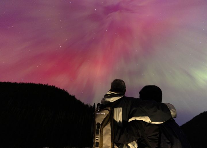 A couple watches the Northern Lights in British Columbia, Canada, May 11, 2024. (ANDREW CHIN / GETTY IMAGES NORTH AMERICA / AFP)