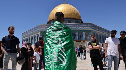 Un Palestinien avec le drapeau du mouvement islamiste Hamas après la prière du vendredi dans l'enceinte de la mosquée al-Aqsa à Jérusalem, le 14 mai 2021. Photo d'illustration. (AHMAD GHARABLI / AFP)