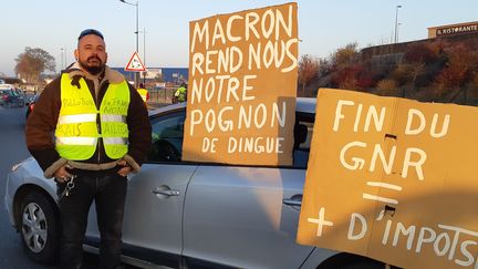 Christian Le Port pose devant sa voiture lors de la manifestation des "gilets jaunes", le 17 novembre 2018, à Thillois, commune limitrophe de Reims (Marne). (YANN THOMPSON / FRANCEINFO)