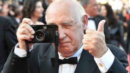 Il ne sort jamais sans son appareil même sur le tapis rouge.
 (ALBERTO PIZZOLI / AFP)