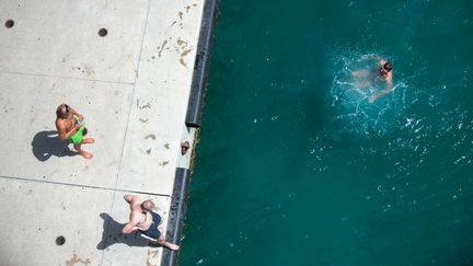 Un homme se baigne aux abords du Mucem, à Marseille (Bouches-du-Rhône), le 2 août 2017. (BERTRAND LANGLOIS / AFP)