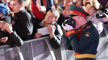 Tout le monde veut sa photo des champions, y compris les militaires russes. surtout quand il s'agit de la m&eacute;daille d'or de patinage artistique remport&eacute;e par la Russie, le 10 f&eacute;vrier 2014.&nbsp; (LOIC VENANCE / AFP)