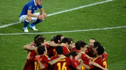 La tristesse du d&eacute;fenseur italien Leonardo Bonucci alors que des membres de l'&eacute;quipe d'Espagne c&eacute;l&egrave;brent leur victoire en finale de l'Euro &agrave; Kiev (Ukraine), le 1er juillet 2012. (JEFF PACHOUD / AFP)