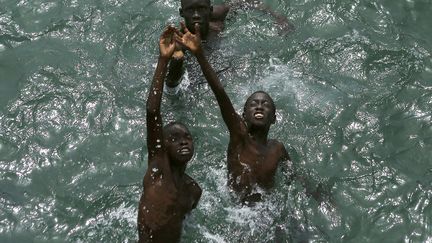 De jeunes gar&ccedil;ons tentent d'attraper des pi&egrave;ces jet&eacute;es au large de l'&icirc;le de Gor&eacute;e (S&eacute;n&eacute;gal), le 26 juin 2013. (GARY CAMERON / REUTERS)