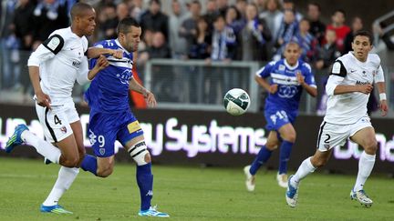 Le Bastiais Yassin Azzouzi (en bleu) &agrave; la lutte avec le d&eacute;fenseur de Metz Mamadou Wague. (PASCAL POCHARD-CASABIANCA / AFP)