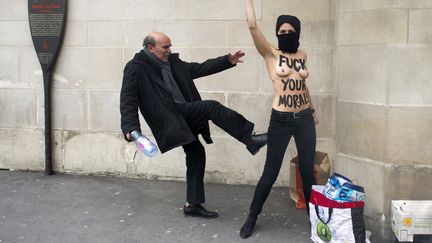 La sc&egrave;ne se d&eacute;roule le 2 avril dernier, devant la Grande Mosqu&eacute;e de Paris. Trois militantes f&eacute;ministes des Femen s&rsquo;y sont rassembl&eacute;es afin de d&eacute;noncer le salafisme en solidarit&eacute; avec Amina, une Femen tunisienne. Les agents de s&eacute;curit&eacute; de la mosqu&eacute;e tentent alors de les d&eacute;loger. C&rsquo;est l&rsquo;un d&rsquo;entre-eux qui frappe l&rsquo;une d&rsquo;elles avec son pied. Le choc des g&eacute;n&eacute;rations comme le raconte le blog Big Browser. (FRED DUFOUR / AFP)