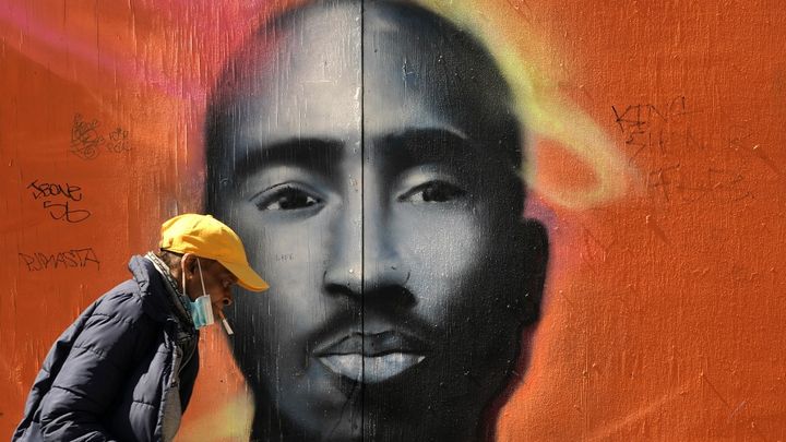 Un passant devant un portrait du rappeur Tupac Shakur dans le quartier new-yorkais de Harlem (Etats-Unis), le 5 mai 2020. (TIMOTHY A. CLARY / AFP)