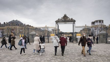 Des visiteurs masqués devant le château&nbsp;de Versailles (Yvelines), le 28 octobre 2020. (MAGALI COHEN / HANS LUCAS / AFP)