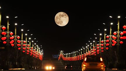 Des automobilistes roulent sous l'œil de la Lune du Castor sur une route de Bazhou, dans la région autonome ouïgoure du Xinjiang (nord-ouest de la Chine), le 16 novembre 2024. (CFOTO / FUTURE PUBLISHING / GETTY IMAGES)