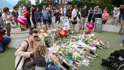 Des fleurs, le 6 juin 2023, dans le parc où six victimes ont été attaquées au couteau à Annecy (Haute-Savoie). (THIERRY GUILLOT / MAXPPP)