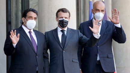 Emmanuel Macron accueille le&nbsp;chef&nbsp;du conseil présidentiel libyen, Mohammed El-Menfi (gauche), et son vice-président&nbsp;Moussa Al-Koni (droite), le 23 mars 2021 à Paris. (LUDOVIC MARIN / AFP)