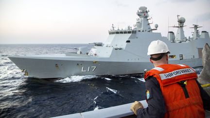 Un membre des forces navales norv&eacute;giennes,&nbsp;dimanche 5 janvier 2014, face au navire de soutien danois qui doit escorter le transport des agents chimiques hors de la Syrie pour leur destruction. (LARS MAGNE HOVTUN / NORWEGIAN ARMED FORCES / AFP)