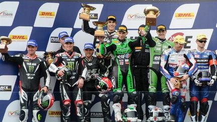 L'écurie Kawasaki célèbre sa victoire sur la première marche du podium (SEBASTIEN BOZON / AFP)