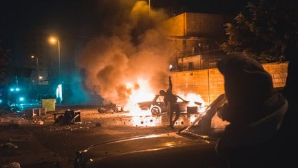 Une voiture brûle, à Tripoli au Liban, en marge de manifestations contre les restrictions sanitaires liées à l'épidémie de Covid-19, le 27 janvier 2021. (BENJAMIN GUILLOT-MOUEIX / HANS LUCAS / AFP)