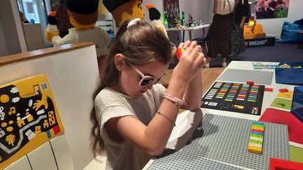 Carmela joue avec des briques Lego qui reproduisent l'alphabet en braille. (SOPHIE AUVIGNE / RADIOFRANCE)