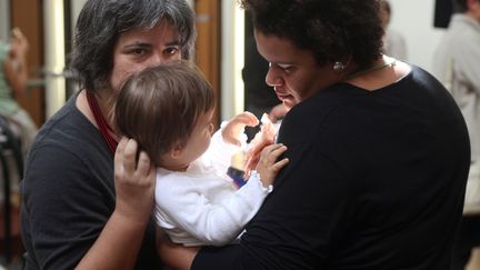 Un couple de femmes homosexuelles tiennent leur enfant, le 17 septembre 2010 &agrave; Paris. (CELINE MIHALACHI / AFP)