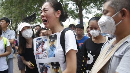 Des familles de victimes de la catastrophe de Tianjin (Chine)&nbsp;laissent &eacute;clater leur col&egrave;re contre la gestion du drame par les autorit&eacute;s, le 16 ao&ucirc;t 2015. (AFP)