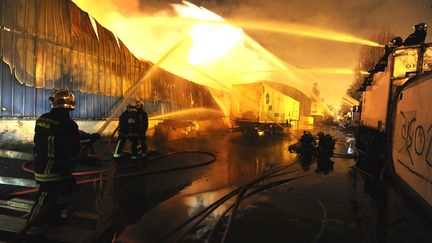 L'incendie dans une zone de 10 000 m2 d'entrep&ocirc;ts &agrave; Gagny (Seine-Saint-Denis)&nbsp;a provoqu&eacute; samedi 10 mars 2012 la chute d'un c&acirc;ble &eacute;lectrique sur une cat&eacute;naire SNCF. (JULIEN PICHOT / SAPEURS POMPIERS DE PARIS / PREFECTURE DE POLICE / AFP)