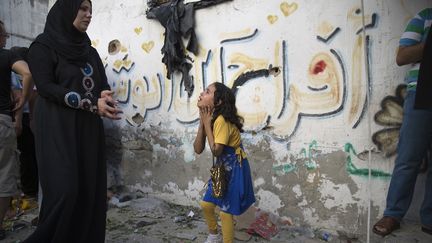 Une enfant palestinienne r&eacute;agit apr&egrave;s l'explosion qui a tu&eacute; huit enfants dans un camp de r&eacute;fugi&eacute;s &agrave; Gaza, le 28 juillet 2014. (FINBARR O'REILLY / REUTERS)