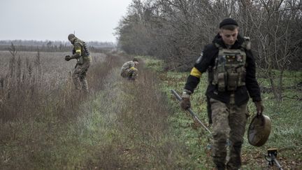 Des militaires de l'unité de déminage inspectent des champs près de la localité de Snihurivka, dans la région de Mykolaïv (Ukraine), le 12 novembre 2022. (NARCISO CONTRERAS / ANADOLU AGENCY / AFP)