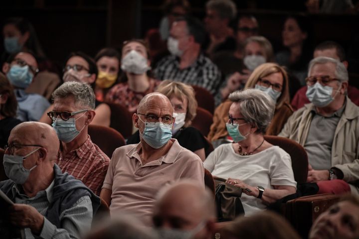 Des spectateurs portent un masque avant d'assister à une représentation au théâtre Antoine, à Paris, le 22 juin 2020. (STEPHANE DE SAKUTIN / AFP)