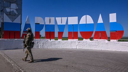 Un panneau&nbsp;de Marioupol peint aux couleurs du drapeau russe, le 12 juin 2022.&nbsp; (YURI KADOBNOV / AFP)