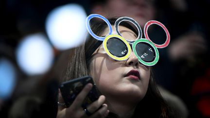 Une spectatrice regarde une épreuve des Jeux olympiques de Pyeongchang (Corée du Sud), le 20 février 2018. (WANG ZHAO / AFP)