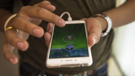 Un&nbsp;homme joue à&nbsp;"Pokémon Go", le 9 août 2016, à Bangkok (Thaïlande).&nbsp; (LILLIAN SUWANRUMPHA / AFP)