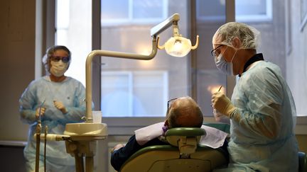 Un dentiste et son assistante traitent un patient&nbsp;urgent&nbsp;au service d'odontologie du CHRU de Nancy (Meurthe-et-Moselle), le 24 mars 2020, pendant le confinement qui a contraint les cabinets dentaires à fermer. (MAXPPP)