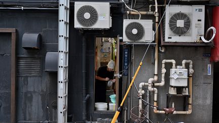 Des climatiseurs à l'arrière d'un restaurant à Tokyo (Japon). Photo d'illustration. (CHARLY TRIBALLEAU / AFP)