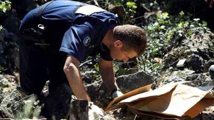 Un gendarme effectue, le 17 mai 2011 à Aups, des fouilles sur les lieux où le corps de Colette Deromme a été retrouvé. (AFP/Sebastien Nogier)