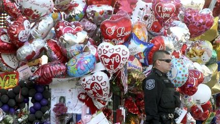 Un policier devant le mémorial de fleurs installé devant l&#039;église
 (Getty-AFP)