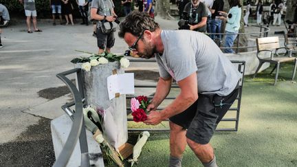 Des passants déposent des fleurs sur les lieux de l'attaque survenue à Annecy (Haute-Savoie), le 8 juin 2023. (OLIVIER CHASSIGNOLE / AFP)