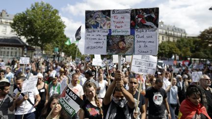 Un manifestant pro-palestinien l&egrave;ve une pancarte &eacute;voquant la Shoah, adress&eacute;e &agrave; Isra&euml;l, le 2 ao&ucirc;t 2014, &agrave; Paris. (KENZO TRIBOUILLARD / AFP)